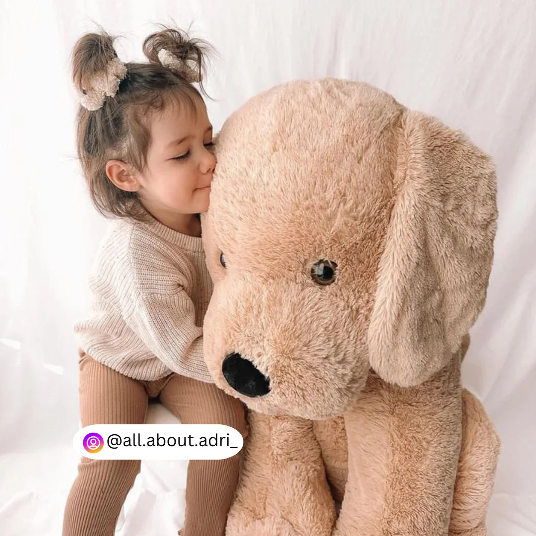 A child hugging an 80cm giant dog plush named Goodaboi from Dreamzity, highlighting the cuddly and comforting nature of the giant dog plush toy.